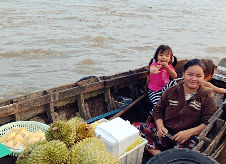 A wooden boat with durians and a cooler on board. 3