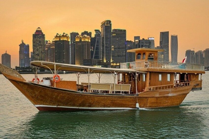 A traditional wooden boat with a cabin, floating on water with a city skyline in the background. 3