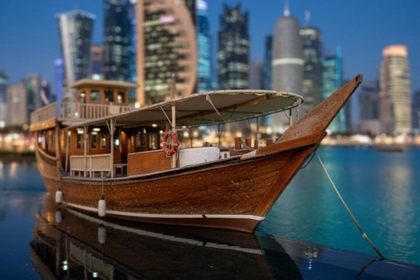 Ein hölzernes Boot liegt in einer Marina vor einer Skyline der Stadt. 4