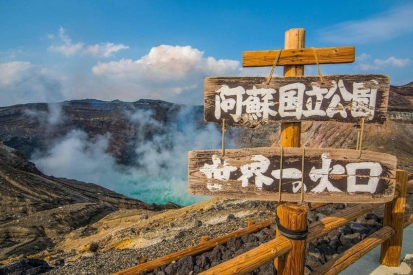 A wooden signpost with Japanese characters, a volcanic landscape, and steam rising from the ground. 3