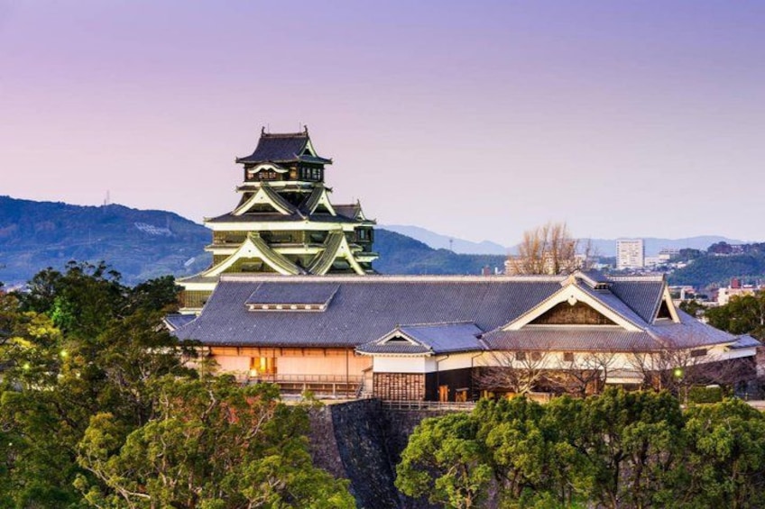 A traditional Japanese castle with multiple tiers, surrounded by lush greenery and mountains in the background. 1