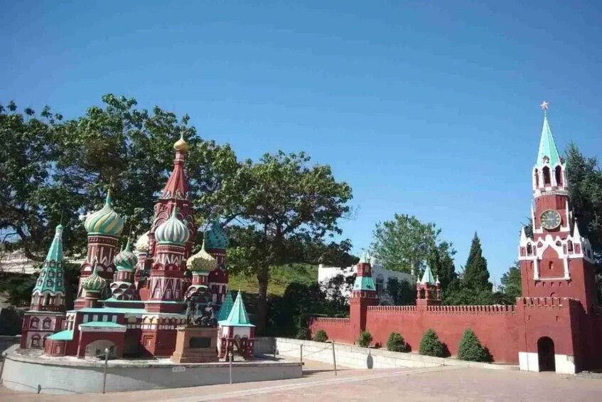 A model of Saint Basil's Cathedral with a clock tower and a red wall. 3