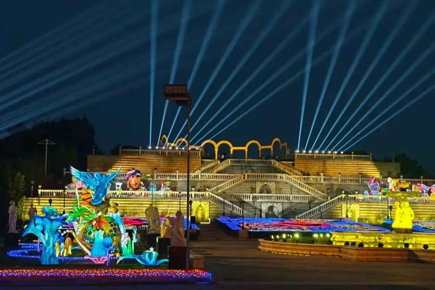 A brightly lit fountain with sculptures and a staircase. 5