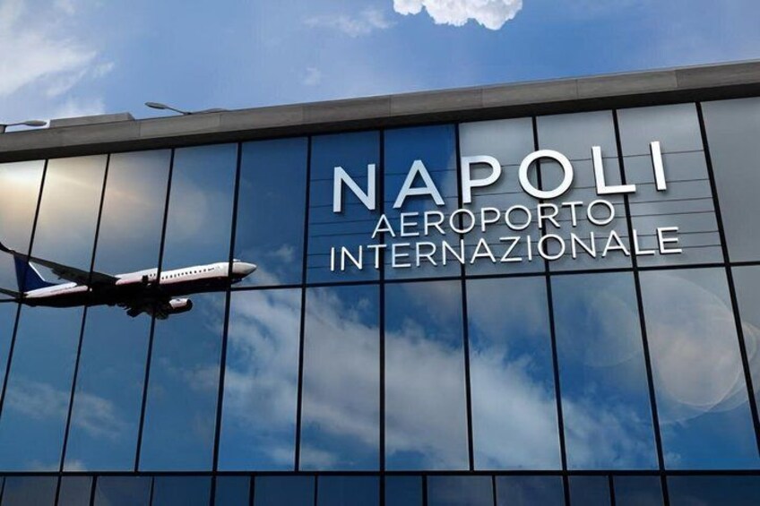 An airplane flying in front of the Napoli Aeroporto Internazionale building. 4