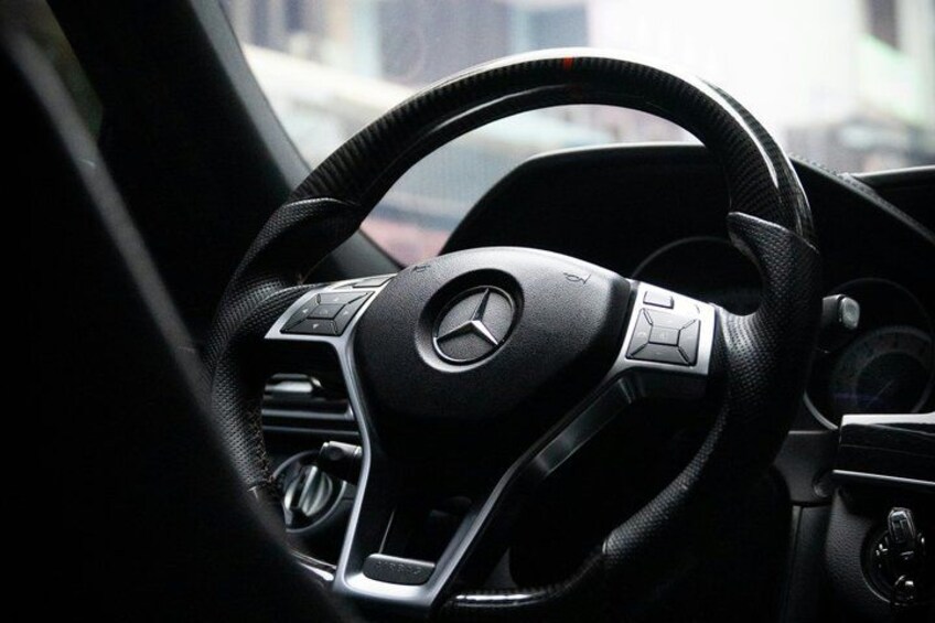 A steering wheel with a logo, a dashboard, and a gear shift. 5