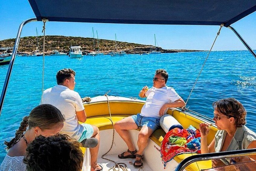 A group of people on a yellow boat in a body of water with a distant shoreline. 2