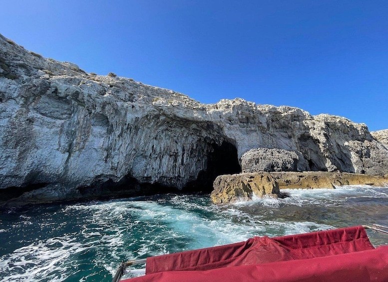 A rocky coastline with a cave entrance and turbulent sea waves. 1