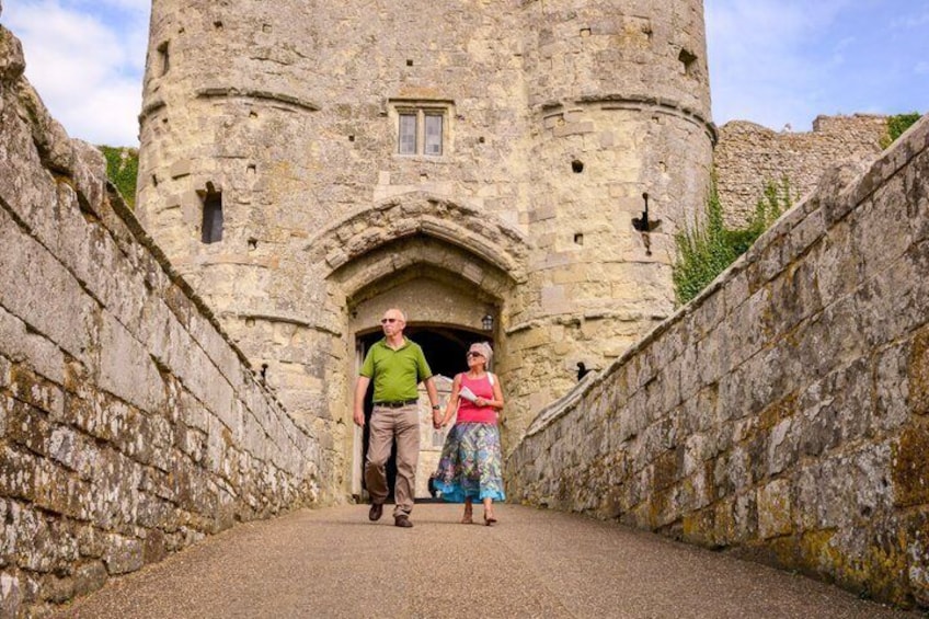 A stone tower with a doorway, a paved path, and a stone wall. 2