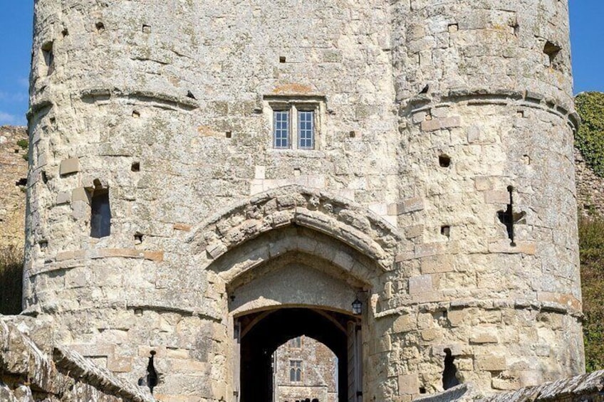 A stone tower with a central arched entrance and a small window. 3