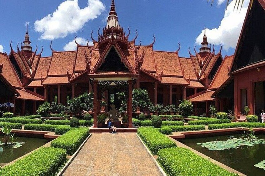 A traditional Thai temple with a central walkway, surrounded by well-manicured gardens and water features. 2