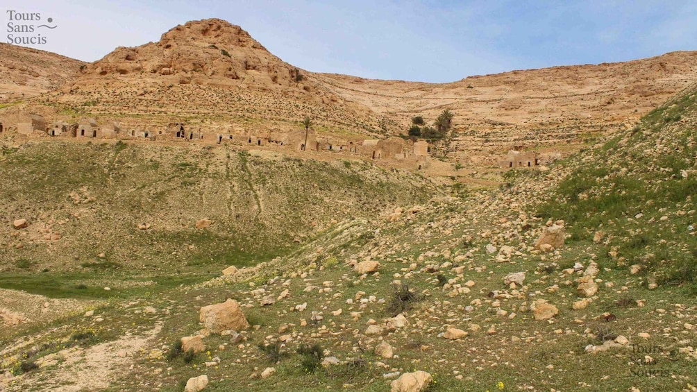 A rugged landscape with a prominent hill and ancient ruins. 1