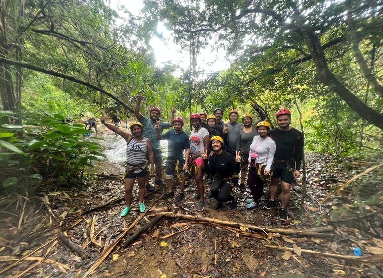 A group of people in a forested area with a muddy path. 4
