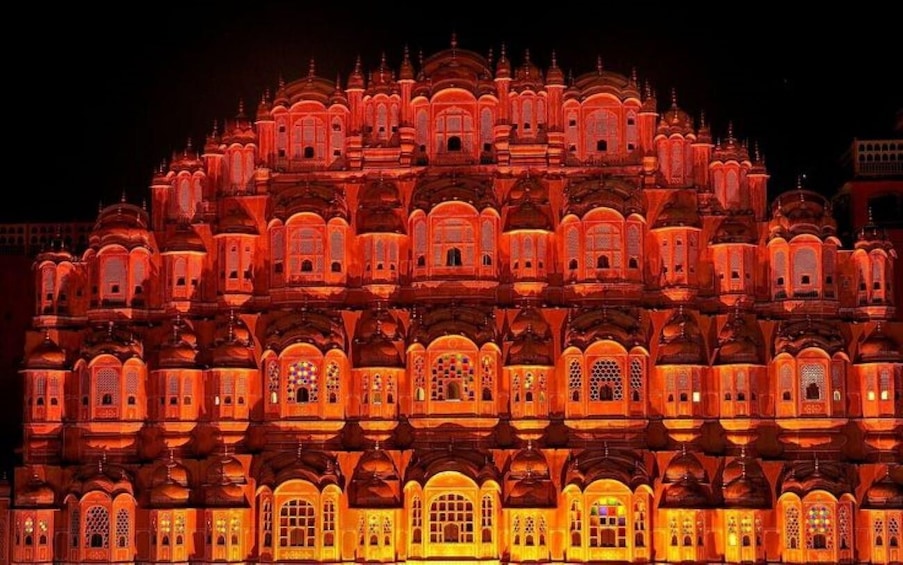 A brightly lit, multi-tiered building with intricate architectural details. 5