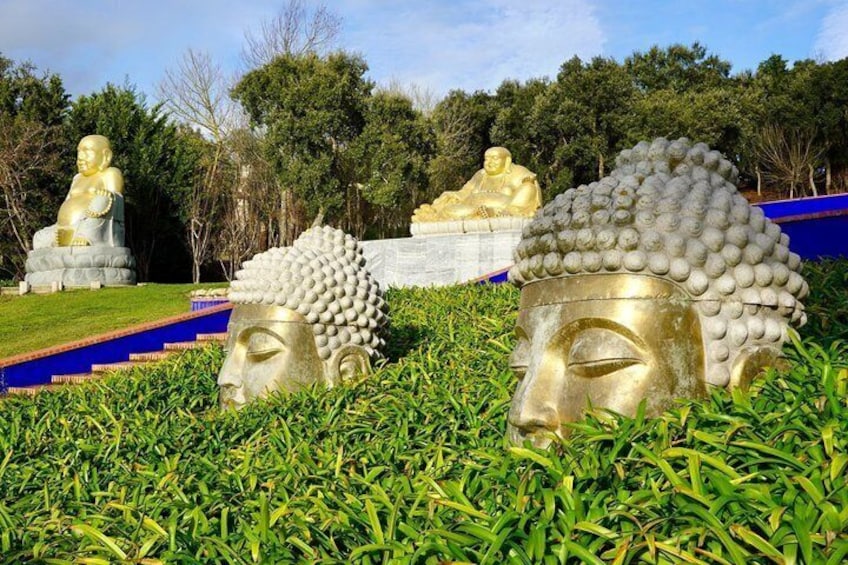 Des statues de Bouddha dorées dans un jardin luxuriant de verdure. 1