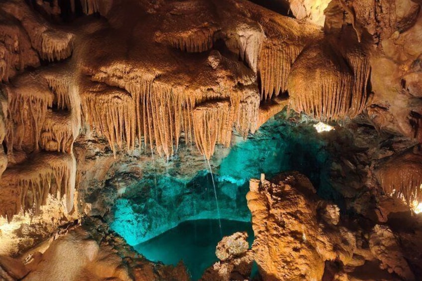 Una cueva con estalactitas y un estanque turquesa. 1
