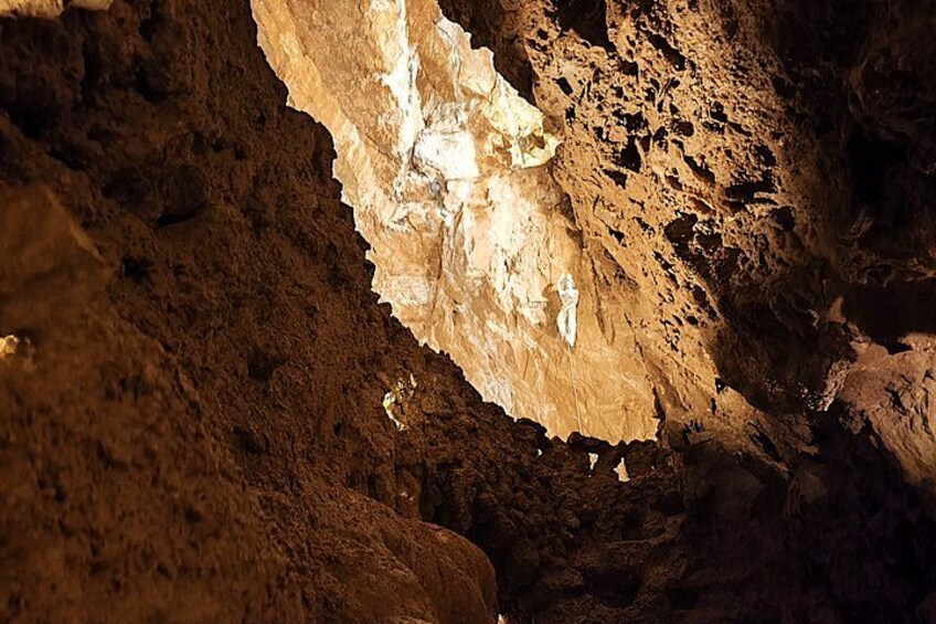 Interior de una cueva con formaciones rocosas y una pequeña entrada. 2