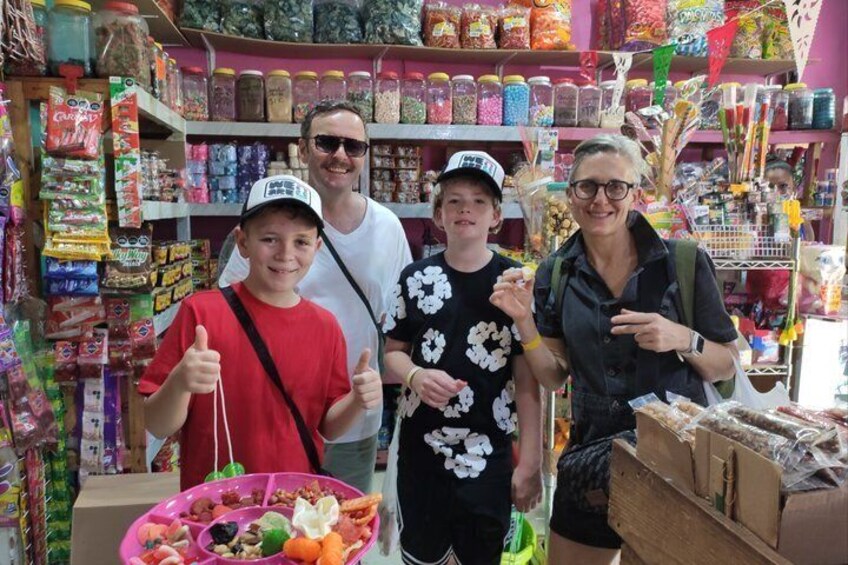 En familie shopper i en farverig butik med diverse produkter på hylderne. 5