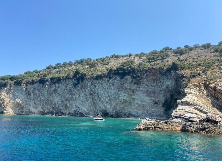 A coastal cliff with a boat in the water. 3