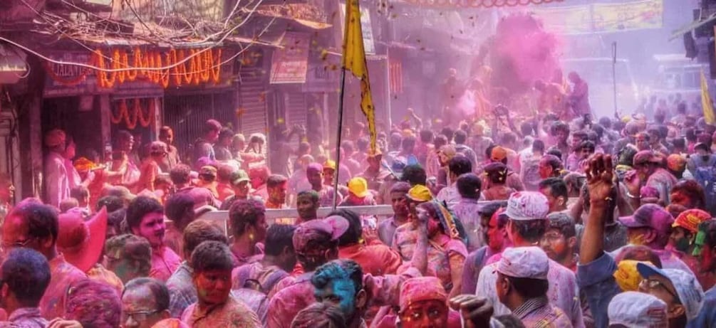A crowded street with people covered in colored powder. 3