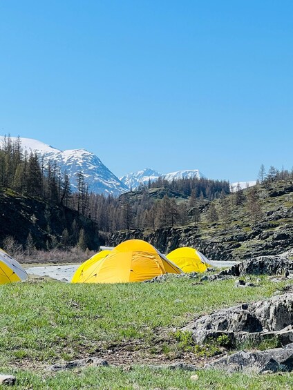 A mountainous landscape with yellow tents and a clear blue sky. 3