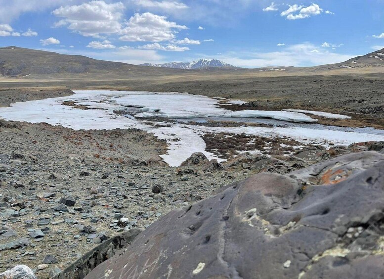 A glacier with ice patches and a rocky terrain. 4