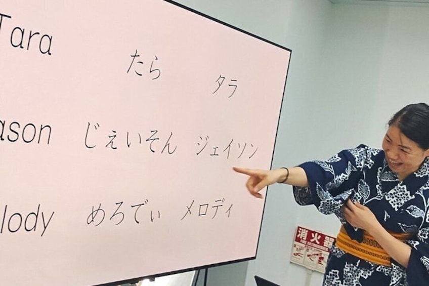 En person som pekar på en whiteboard med japansk text. 2