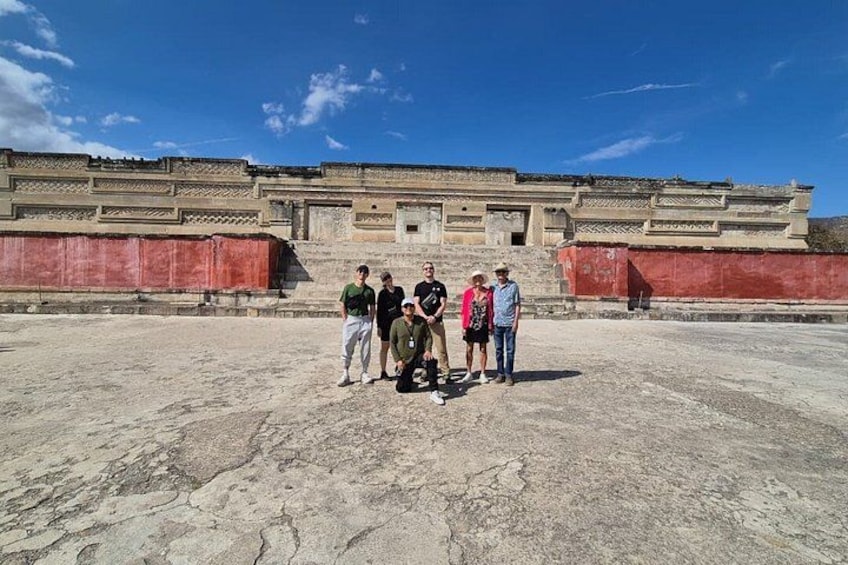 Un grupo de personas frente a una gran estructura de piedra antigua con terrazas escalonadas. 3