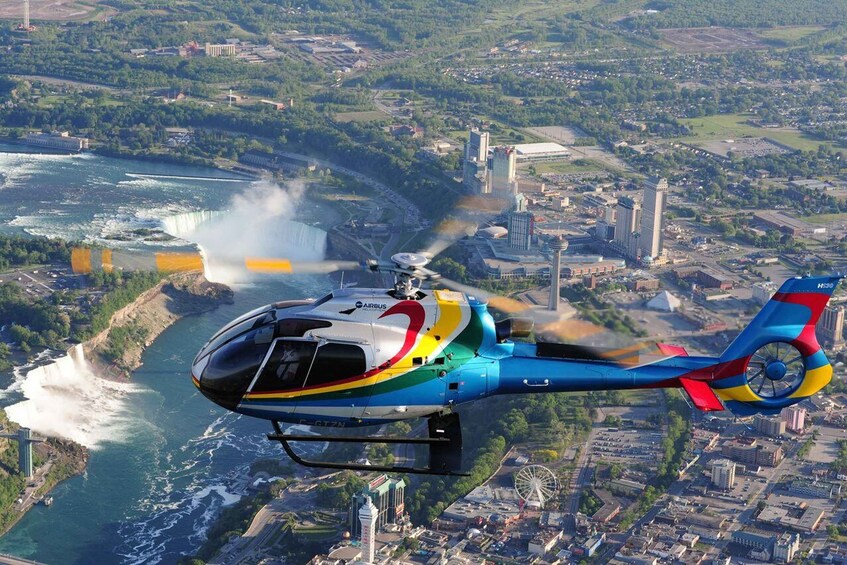 A helicopter flying over a city with a waterfall in the background. 3