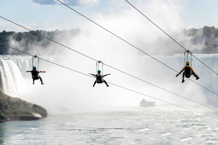 Three people bungee jumping from a bridge over a waterfall. 1