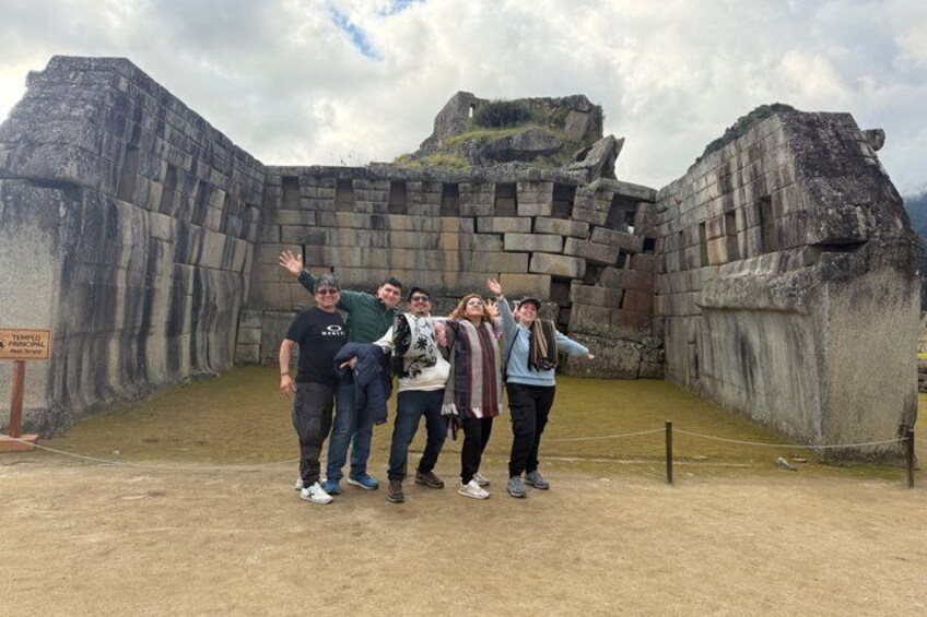 Een groep mensen staat voor oude stenen muren op een historische locatie. 5
