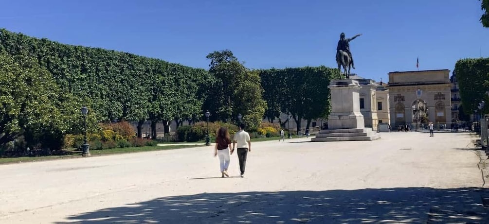 A statue in a square with a hedge in the background. 4