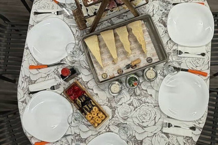 A table set with white plates, a tray of cheese, condiments, and a decorative box. 3