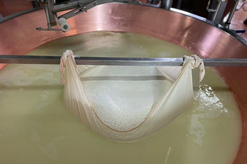 A large copper vat with a cloth hanging over a rod, likely used for industrial processes. 2