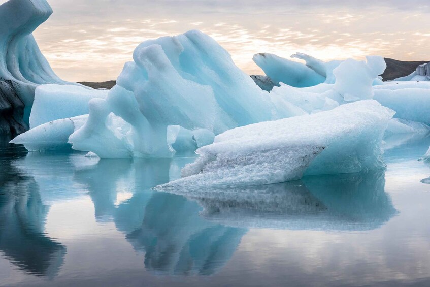 Large icebergs floating in calm water with a clear sky. 3