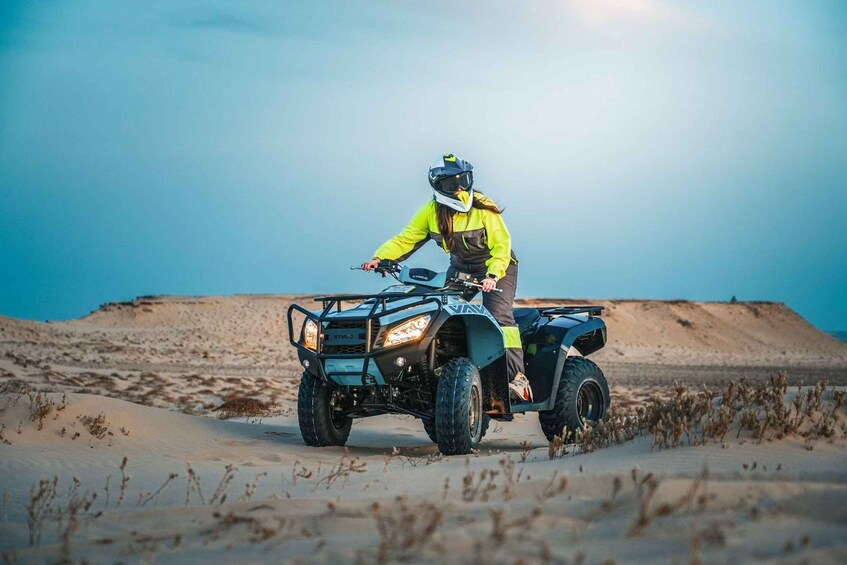 A person riding an ATV in a desert landscape. 2
