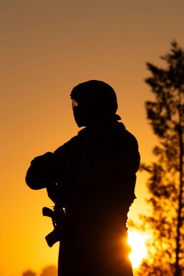 A silhouette of a person holding a camera against a sunset. 1