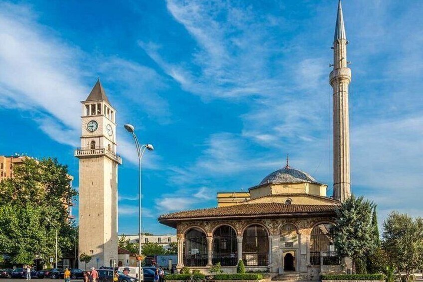 A clock tower, a mosque with a minaret, and a building with arched windows. 2