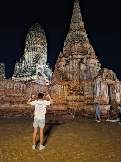 A person taking a photo of a temple at night. 5
