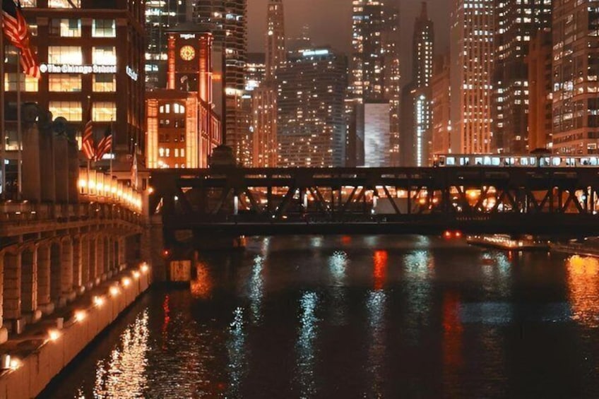 Un paisaje urbano nocturno con edificios iluminados, un río y un puente. 3