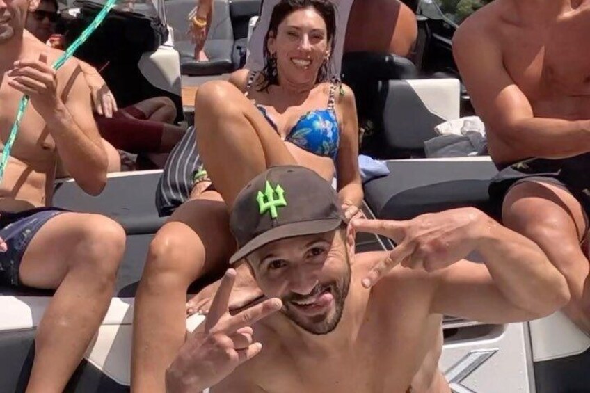 Una persona con gorra y un símbolo verde, sentada en un bote junto a otras personas. 4