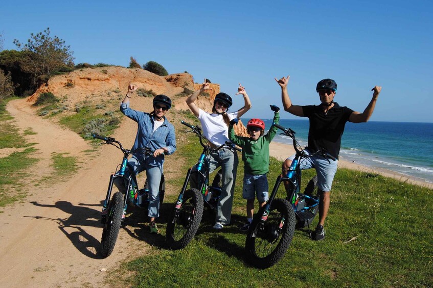 A group of people with bicycles on a coastal path. 1