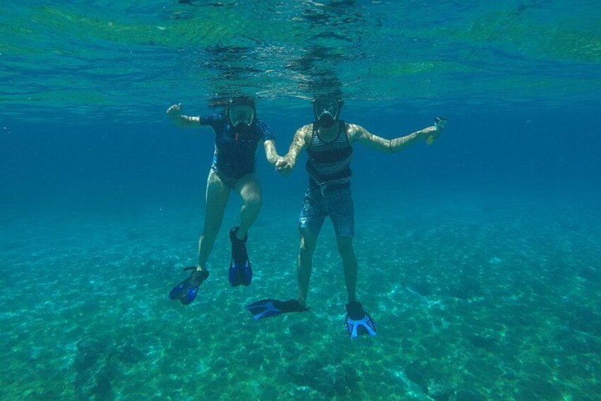 Deux personnes font de la plongée avec tuba dans une eau cristalline et bleue. 3
