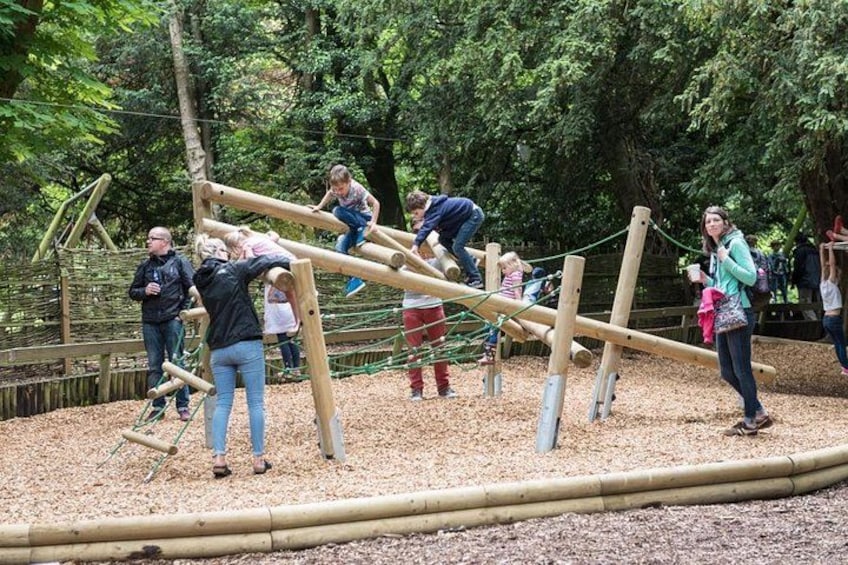 People playing on a wooden climbing structure in a park. 5