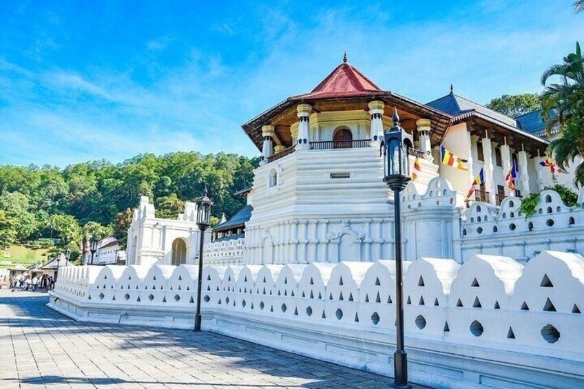 A white temple with a red roof, surrounded by a white fence with pointed tops. 1