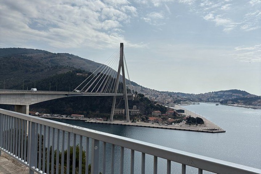 Un puente atirantado sobre un río, con colinas al fondo y un cielo despejado. 2