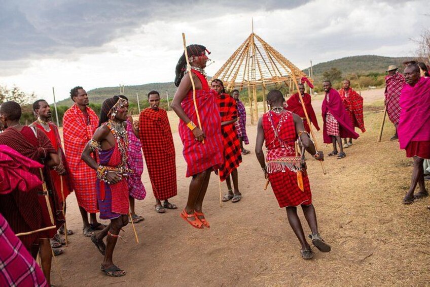 A group of people in traditional attire, a wooden structure, and a dry landscape. 5