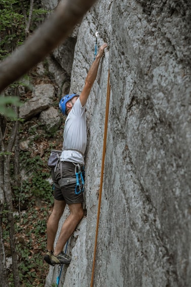 A person climbing a rock face with safety gear. 4