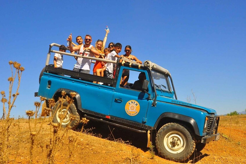 A blue safari vehicle with passengers enjoying a ride. 3