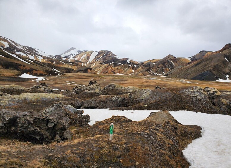 A rugged mountainous landscape with snow patches and a rocky foreground. 4