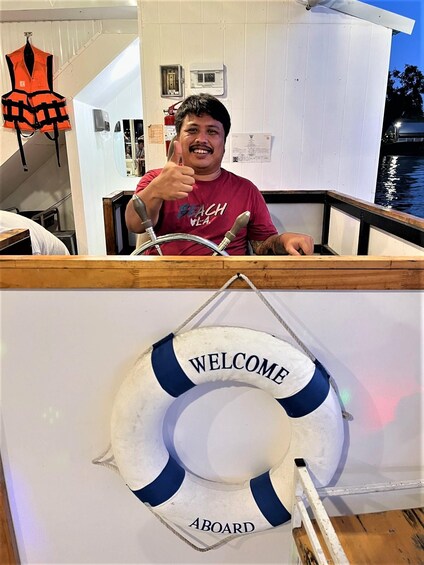 A person in a red shirt giving a thumbs-up, a life preserver with 'WELCOME ABOARD' text, and a boat's railing. 5
